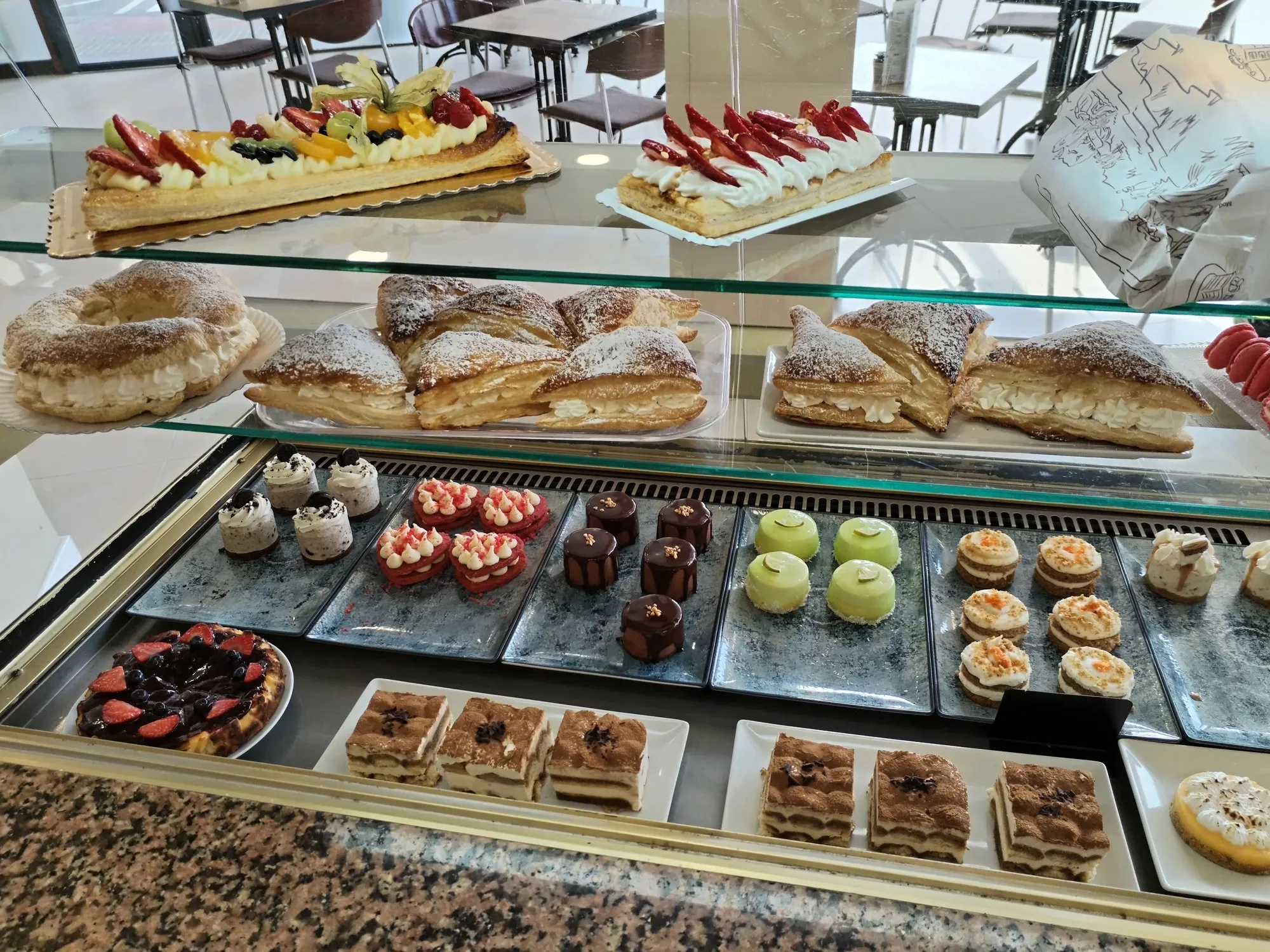 El mostrador de Dulce Valery con la vitrina de pasteles y, al fondo, las mesas de la cafetería